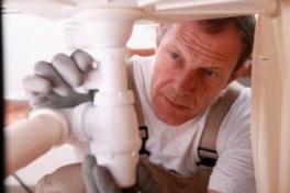 a professional Modesto plumbing tech is performing maintenance on a kitchen sink